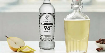 Pera cortada y estrellas de anís junto a botella de alcohol LICORERO para elaborar licor artesano.