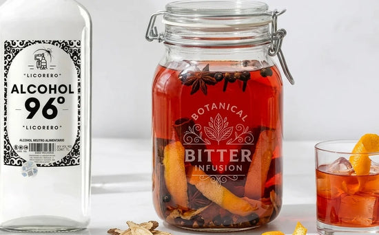 Frasco de cristal macerando bitter rojo artesanal con piel de naranja y botánicos.